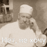 a man with a beard wearing a white hat and a white shirt with the words het he хочу written below him
