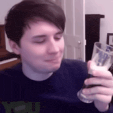 a man in a blue shirt is holding a glass of beer in his hand .