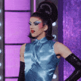 a woman in a blue dress and black gloves
