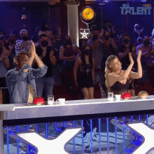 a group of people are applauding in front of a sign that says espana talent