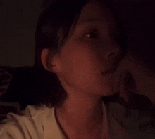 a woman is taking a selfie in the dark with her hand on her face