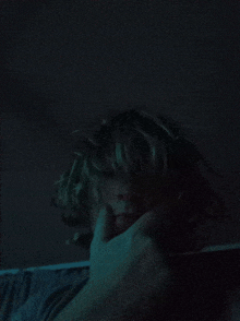 a close up of a person 's face with a hand on it