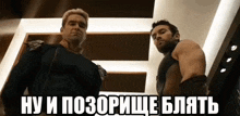 two men are standing next to each other in a room with russian writing on the bottom .