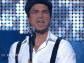 a man singing into a microphone with the number 13 on the bottom right