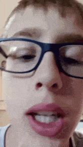 a close up of a person wearing glasses making a funny face .