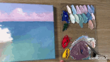 a painting is being painted on a canvas next to a palette