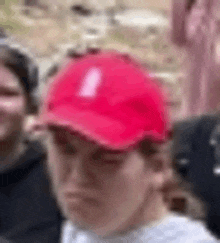 a man wearing a red hat is standing in a crowd .