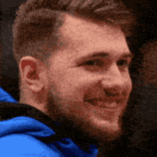 a close up of a man 's face with a blue jacket on