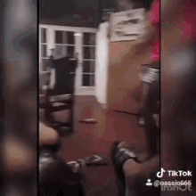 a group of people are standing in a living room with a dog .