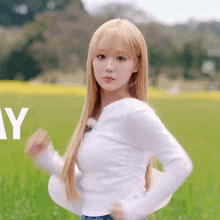 a woman in a white shirt is standing in a field with the letter y in the foreground