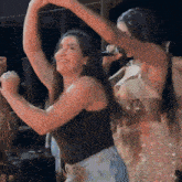 a woman singing into a microphone while another woman dances