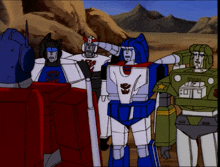 a group of transformers are standing in a desert and one of them has a sticker on his chest that says sdg