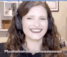 a woman wearing headphones is smiling and laughing while looking at the camera