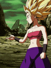 a woman in a pink top and purple pants is standing on a rocky surface