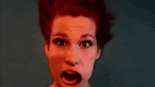 a woman with red hair is making a surprised face with her mouth open
