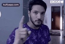 a man with a beard is giving a thumbs up sign .
