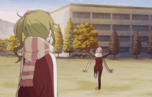 a girl in a scarf stands in front of a large building