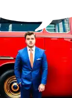 a man in a blue suit and orange tie stands in front of a red van