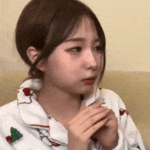 a young girl is sitting on a couch and making a funny face with her hands .