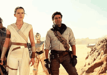 a man with the letter i on his belt stands next to a woman and a robot