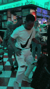 a man in a white nike shirt is dancing in front of a sign that says burrito