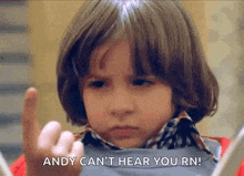 a young boy is pointing at something with his finger and says `` andy can 't hear you rn ! ''