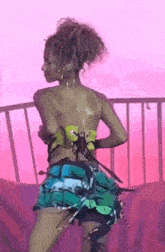 a woman is dancing on a stage wearing a very short skirt and a yellow top .