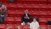 a man sitting in a stadium with a sweatshirt that says ' detroit '