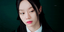 a close up of a woman 's face with a green background and the word jmv on the bottom