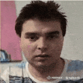 a man in a blue and white striped shirt is looking at the camera .