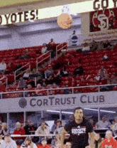 a man in a coyotes shirt stands in front of a crowd in a stadium