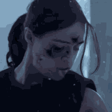 a close up of a woman 's face with a bullet hole in it .