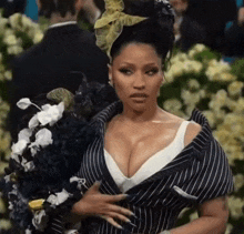 a woman in a black and white striped dress holds flowers in her hand
