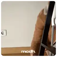 a person sitting on a chair with the word mcdh on the bottom right