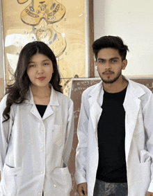 a man and a woman standing next to each other in front of a chalkboard that says r. roy