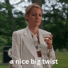 a woman in a suit and tie is holding a glass of wine with the words a nice big twist above her