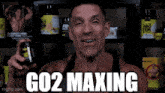 a man holding a bottle of co2 maxing in front of a shelf of supplements