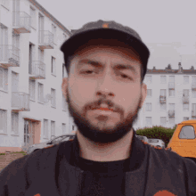 a man with a beard wearing a hat and a jacket