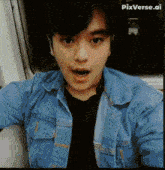 a man in a blue denim jacket is taking a selfie with pixverse.ai written below him