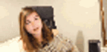 a blurry picture of a woman sitting in a chair in a living room .