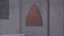 a man in a red costume is standing in a room with a man in a black suit .