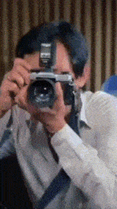 a man is taking a picture with a camera that has the word canon on it