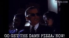 a man in a suit and tie is saying go get the damn pizza now