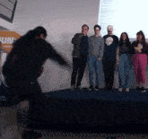 a group of people standing on a stage with one man wearing a shirt that says ' artesa '