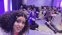 a group of people are sitting on the floor and one of them has a name tag that says ' a ' on it