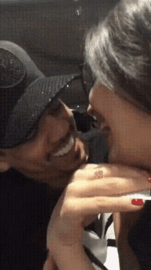 a man and a woman are kissing and the woman is wearing sunglasses
