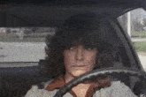 a woman drinking from a glass while driving