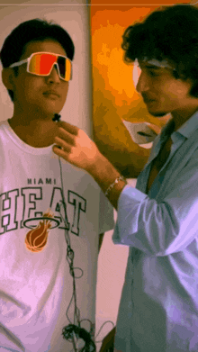 a man in a miami heat shirt is being interviewed by another man