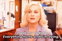 a woman in a suit is talking about her period and everything hurts and she is dying .