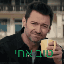 a man is holding a cup of coffee with the words " i love you " in green letters